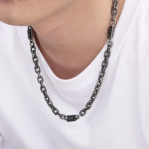 Detail of gunmetal titanium steel chain with industrial spring accents on white t-shirt