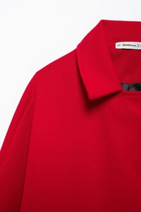 Close-up of red wool coat collar with label showing size EUR M and fabric texture