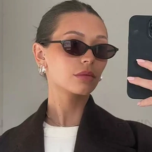 Retro black narrow frame sunglasses and silver earrings worn by model for Y2K style