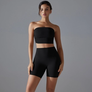 Detail of high-waisted fitness shorts and ruched sports top in black stretch fabric