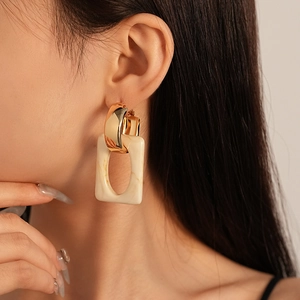 Detail of geometric resin earring with marble texture on female model in close-up shot