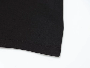 Gros plan sur les coutures plates et la texture d'une robe midi noire à manches longues
