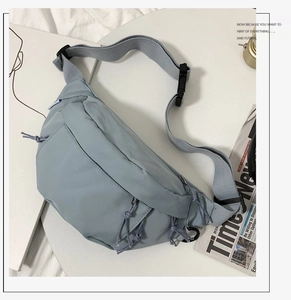Detail of gray-blue nylon crossbody bag showing adjustable strap and secure buckle
