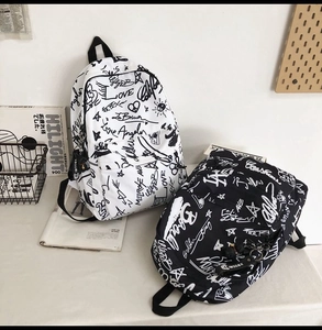 Close-up of black and white backpacks with American street graffiti and front zipper pockets