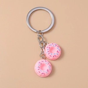 Close-up of cute pink donut pendants with colorful sprinkles on a metal keychain