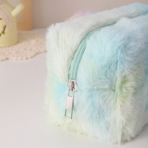 Detailed close-up of a sturdy metal zipper on a soft gradient plush cosmetic pouch