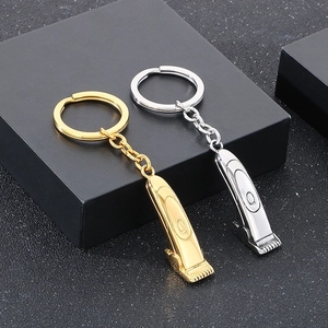 Detail of barber clipper pendants in gold and silver steel on black display stand