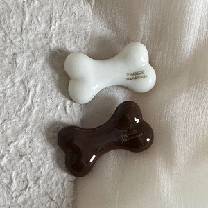Detail of bone-shaped hair clips in cream and brown with France Handmade print