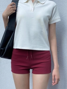 Detail of high-waist wine red gym shorts with drawstring and white polo shirt