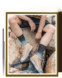 Outdoor shot of khaki high-top canvas sneakers with white rubber toes and gradient socks