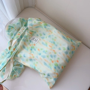 Detail of mint green watercolor chiffon tote bag with tie-dye patterns and white handle