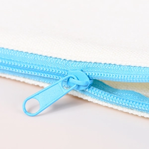 Off-white canvas zipper pouch with light blue zipper detail in a close-up product view