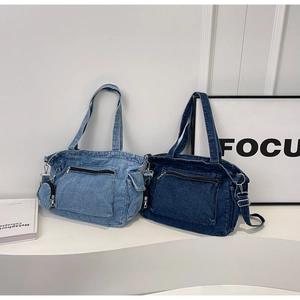 Detail of light and dark blue denim tote bags with front zippers and mini coin purse
