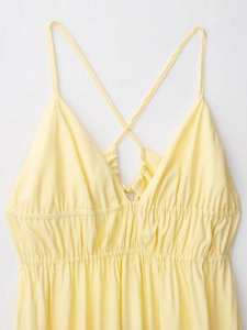 Détail d'une robe d'été jaune clair avec fines bretelles croisées et taille élastique