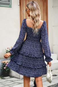 Back view of a floral mini dress featuring long sleeves and a multi-layered skirt design