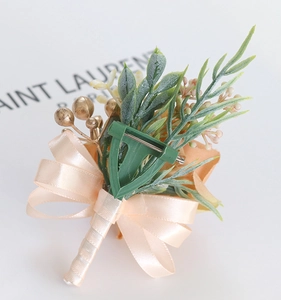 Detailed back view of champagne wedding boutonniere with ribbon bow and metal safety pin
