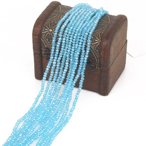 Sky blue faceted crystal glass beads strands draped over a vintage wooden jewelry box