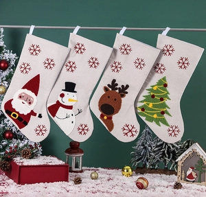 Détail de quatre chaussettes de Noël avec broderies Père Noël et renne sur lin