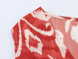 Détail de l'imprimé géométrique abstrait rouge et blanc sur robe longue en mousseline