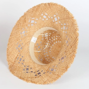 Handmade hollow crochet raffia straw hat with frayed edges for beach vacations