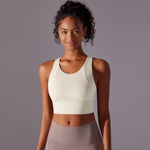 Detail view of cream high-support sports bra and mauve high-waist yoga pants on a model
