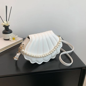 Minimalist white shell-shaped crossbody bag with pearl handle and vertical texture