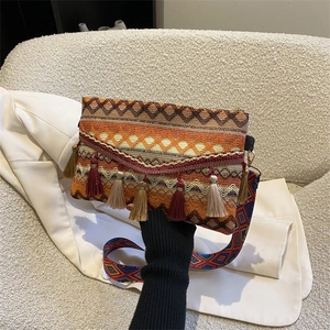 Close-up of Bohemian woven crossbody bag with colorful tassels and ethnic pattern strap