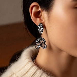 Détail de boucles d'oreilles pendantes vintage en strass portées par un mannequin