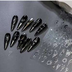 Macro detail of black and silver gothic nail stickers with butterfly and moon patterns