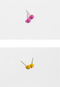 Close-up of vibrant rose pink and bright yellow minimalist ball stud earrings