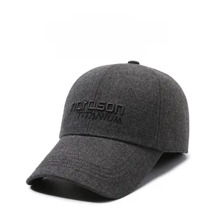 Detailed view of the dark grey wool texture and titanium embroidery on the earflap cap