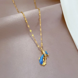 Dettaglio macro del ciondolo a delfino con smalto blu e intarsio di cristalli lucidi