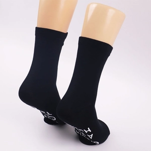 Detailed view of black novelty socks with I AM A white printed lettering on the sole