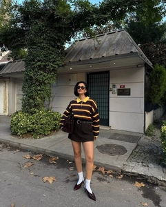 Detail of autumn striped Polo sweater with brown mini skirt and leather handbag