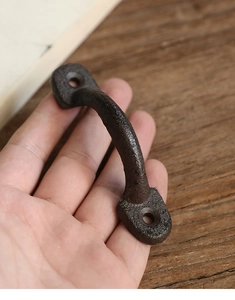 Gros plan détaillé sur une poignée en fonte rétro montrant la texture et les dimensions