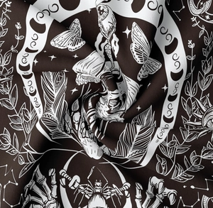 Close-up of gothic tapestry fabric showing mystical moon and skeleton print details