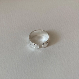 Top view of minimalist S925 sterling silver open ring with elegant heart detail on white surface
