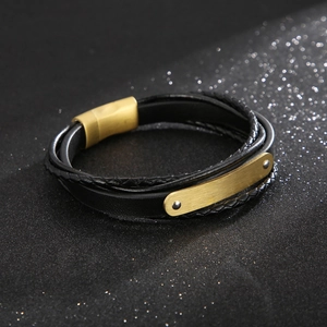 Dettaglio di un bracciale multistrato in pelle nera con chiusura magnetica dorata
