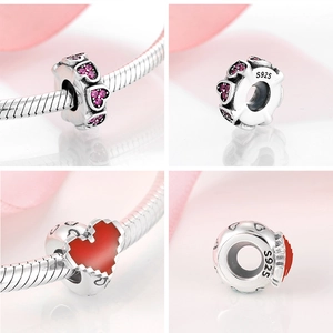 Macro detail of S925 sterling silver charms with pink and red pixelated heart patterns