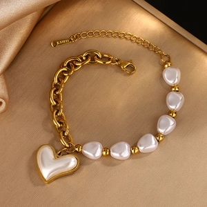 Stainless steel gold bracelet with irregular pearls and a white heart pendant charm