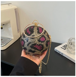 Detailed macro shot of spherical sequin evening bag with leopard pattern and gold handle