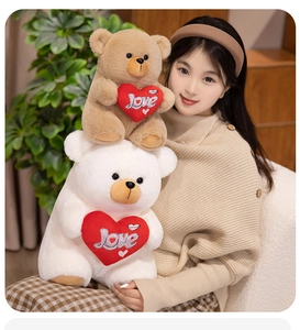 Close-up of plush teddy bears holding red hearts with embroidered Love text and lip prints