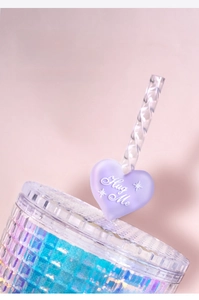 Dettaglio del copri cannuccia in silicone viola a forma di cuore con testo Hug Me su tazza