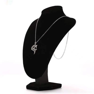 Detail of silver wolf head pendant necklace displayed on a professional black mannequin stand