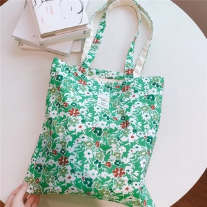 Close-up of green floral cotton tote bag with reinforced handles and vintage fabric label