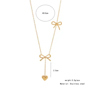 Detail view of golden bow necklace with heart pendant and product measurements