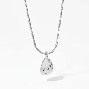 Macro shot of silver snake chain necklace featuring a polished drop pendant and glossy finish