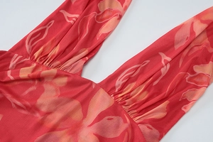 Détail du décolleté en V plongeant et imprimé floral orange sur robe en résille rouge