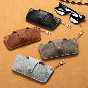Handmade leather sunglasses cases in multiple colors with metal hooks on orange background