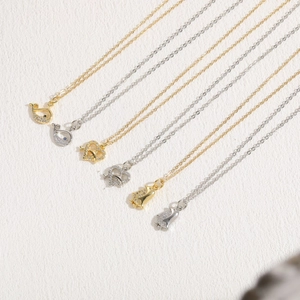 Close-up of ocean series 14K gold plated necklaces with whale, heart and penguin pendants